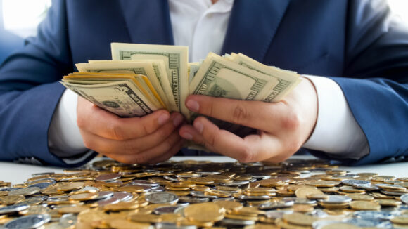 Closeup image of rich wealthy businessman counting big stack of money