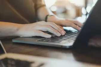 Closeup image of hands working and typing on laptop keyboard