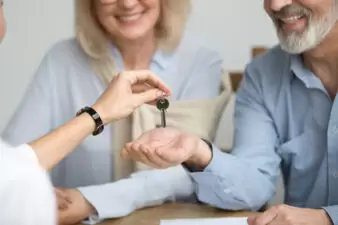 Realtor giving senior couple keys to new house