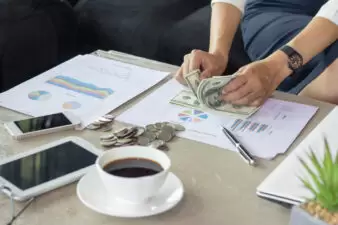 woman counting out money and creating a budget