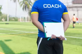 Coach holding a clipboard