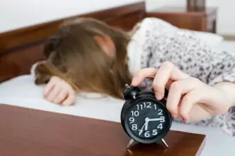 Girl turns off alarm clock