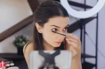 brunette woman putting on mascara