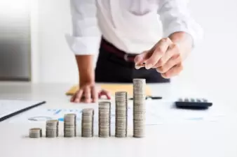 Closeup view of person stacking coins on a table