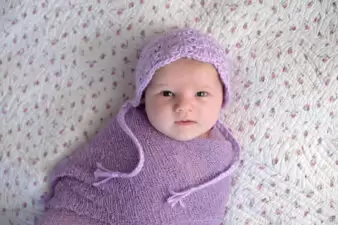 Baby girl swaddled in lavender blanket