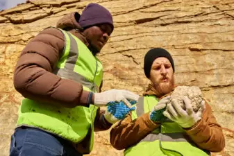 Men inspecting a rock at an archaeological dig