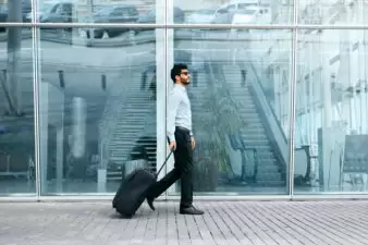 Man pulling rolling suitcase on a business trip