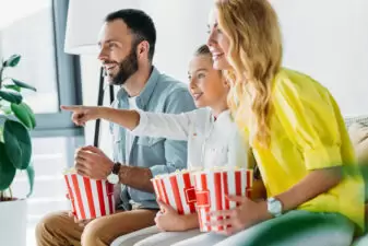 family watching a movie at home with popcorn