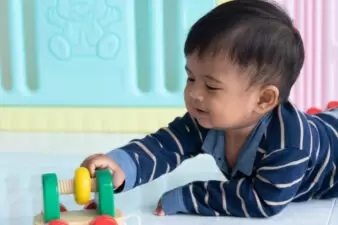 happy little boy playing with his toys on the floor