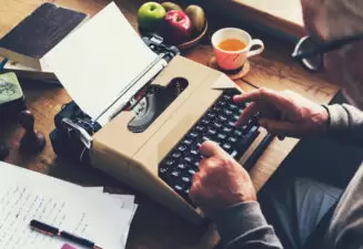 Old man typing on a typewriter