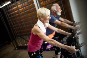 Fit older couple on exercise bikes