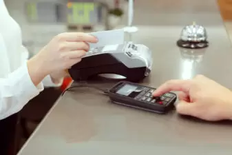 Guest at hotel reception paying with check during check-in