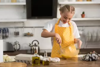 adorable smiling girl cooking in kitchen