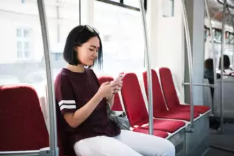 Young woman sitting on a chair looking at her phone