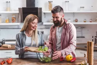 cheerful couple cooking together in the kitchen