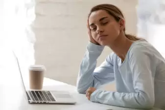 Tired woman sitting in front of laptop