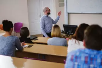 Male teacher lecturing in front of classroom