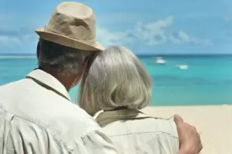 Elderly couple looking at the water on a beach