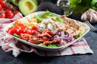 Healthy cobb salad with chicken, avocado, bacon, tomato, and eggs