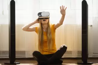 Girl wearing virtual reality goggles at home