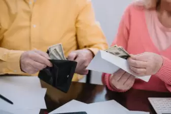 cropped view of senior couple holding wallet and envelope with money