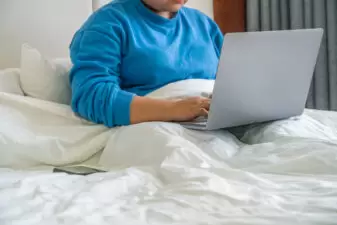 Person on laptop on hotel bed