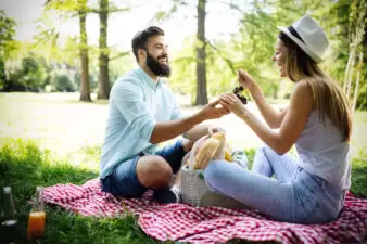 Happy young couple enjoying a picnic in the park together