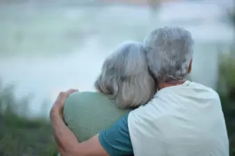 Senior woman and man hugging and looking out at a beautiful sight