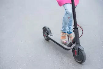 Female in high heels holding a scooter