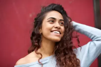 Smiling young woman with hand behind head