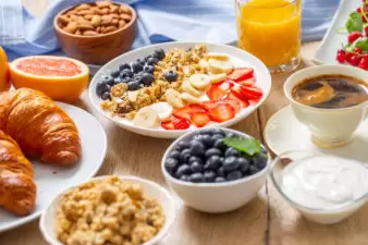 Healthy breakfast served with plate of yogurt muesli blueberries strawberries and banana