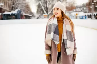 Girl dressed in winter clothes walking outside in snow