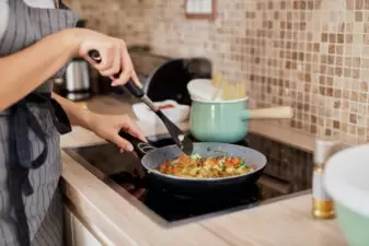 Woman in apron cooking at a stove