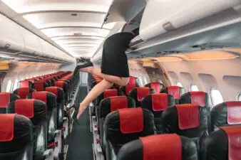 Flight attendant legs sticking out of overhead compartment