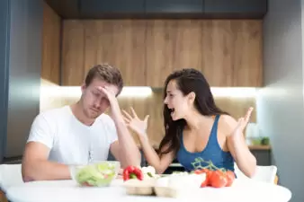 young couple having fight while cooking breakfast in the kitchen wife