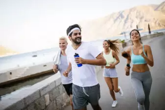 Outdoor portrait of group of friends running and jogging in nature