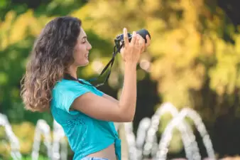 Smiling woman taking a photo while on a walk