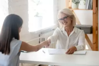 Older woman shaking hands at job interview