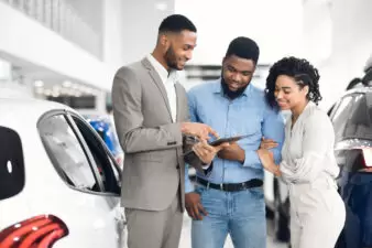 Car salesman offering couple a deal on car