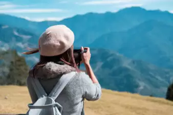 Young woman traveler taking a picture of beautiful landscape