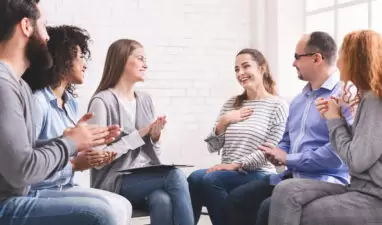 Happy woman sharing her progress with group in rehab