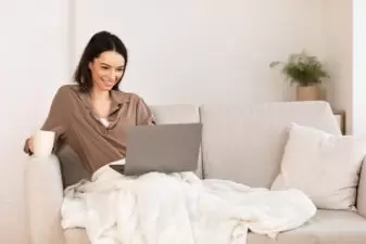 Young woman using laptop sitting on the couch