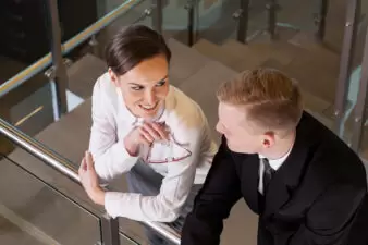 Business woman and man having a conversation by a railing