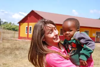 A woman at a non-profit holding a child in Africa