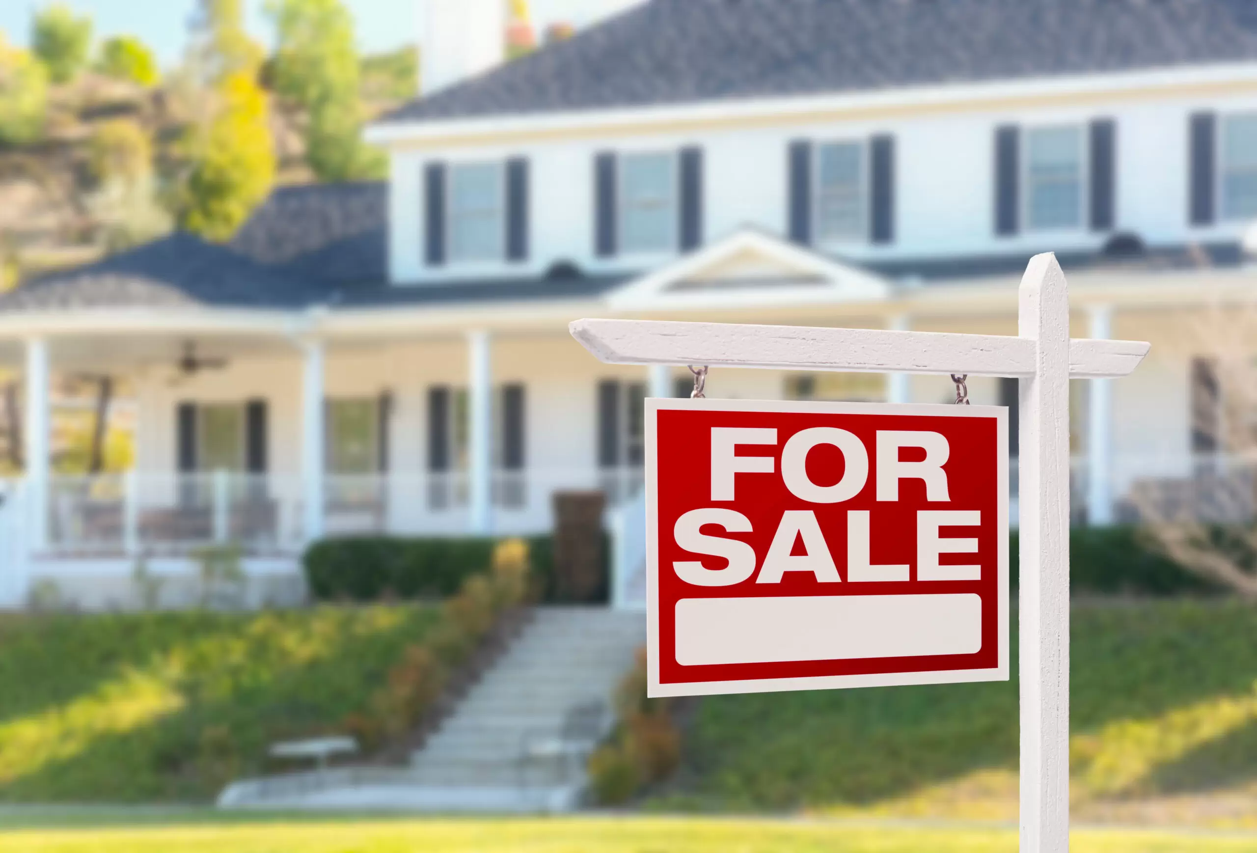 for sale sign in front of a house