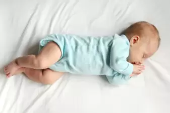 Sleeping baby in a blue onesie