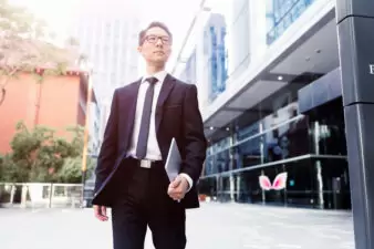 Businessman standing in front of business holding a notebook