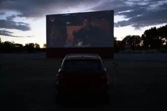 Dark view of car watching movie at drive-in theater