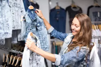 Woman choosing denim jacket in shop