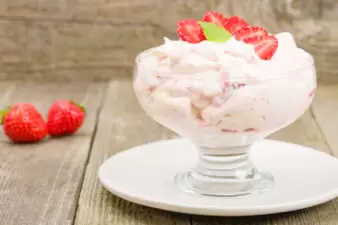 Strawberry yogurt in glass cup on white plate